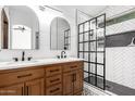 Stylish bathroom with double vanity, wooden cabinets, and a glass-enclosed shower at 3528 W Paseo Way, Laveen, AZ 85339