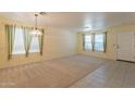 Bright living room with a ceiling fan, neutral carpet and trim, and many windows at 3665 E Thames Way, San Tan Valley, AZ 85140