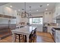 Spacious white kitchen with a large marble island, stainless steel appliances, and hardwood floors at 3813 N 37Th St, Phoenix, AZ 85018