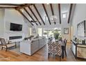 Bright living room featuring vaulted ceilings with wood beams, fireplace, and hardwood floors at 3813 N 37Th St, Phoenix, AZ 85018
