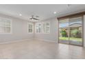 Bright and airy living room features tile flooring, a ceiling fan, neutral paint, and sliding glass doors at 3892 E Harrison St, Gilbert, AZ 85295