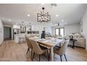 Open-concept dining area features wood flooring, modern lighting, and seamless flow to the kitchen and living spaces at 4234 E Winnetka Dr, Phoenix, AZ 85044
