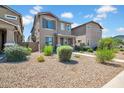 Charming two-story home featuring neutral paint, desert landscaping, and inviting front porch entry at 5741 W Warner St, Phoenix, AZ 85043