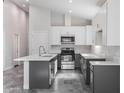 Open kitchen featuring white cabinets, a gray island with a sink, and stainless steel appliances at 9310 W Washington St, Tolleson, AZ 85353