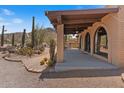 Side exterior view showing covered patio with beautiful arched windows, desert landscaping at 9607 E Mckellips Rd, Mesa, AZ 85207
