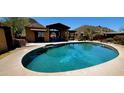 Beautiful backyard pool with well manicured desert landscaping and outdoor kitchen and seating area at 9607 E Mckellips Rd, Mesa, AZ 85207