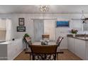 Cozy dining area with rustic wood table and a decorative light fixture under a bright window at 10465 W Windsor Blvd, Glendale, AZ 85307