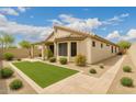 Well-manicured backyard featuring artificial turf, desert landscaping, covered patio, and a neutral color palette at 11807 E Clinton St, Scottsdale, AZ 85259