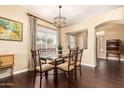 Elegant dining room with hardwood floors, stylish chandelier, and natural light from the window at 11807 E Clinton St, Scottsdale, AZ 85259