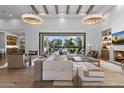 Open living room featuring modern furniture, hardwood floors, and large windows to an outdoor living space at 12240 N 98Th St, Scottsdale, AZ 85260