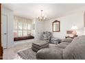 Bright living room featuring a cozy window seat, elegant chandelier, and comfortable seating at 1309 E Meadow Ln, Phoenix, AZ 85022