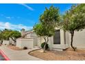 Charming condo featuring an orange tiled roof, decorative wall, and flourishing trees, capturing a warm and inviting curb appeal at 1717 E Union Hills Dr # 1033, Phoenix, AZ 85024