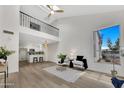 Bright, airy living room featuring high ceilings, wood floors, and open access to a modern kitchen with white cabinets at 1717 E Union Hills Dr # 1033, Phoenix, AZ 85024
