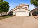 Two-story home featuring a well-maintained lawn, mature trees, and a spacious two-car garage at 20404 N 28Th Pl, Phoenix, AZ 85050