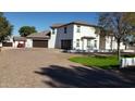 A beautiful rear exterior showcasing a spacious driveway, lush lawn, and a pristine white exterior finish at 2060 E Quartz St, Mesa, AZ 85213