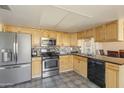 Well-equipped kitchen features stainless steel appliances, maple cabinets, and a backsplash tile design at 2201 W Wethersfield Rd, Phoenix, AZ 85029