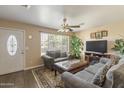 Cozy living room featuring plush seating, a ceiling fan, and natural light streaming through the window at 2201 W Wethersfield Rd, Phoenix, AZ 85029