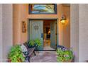 Inviting entryway featuring double doors, stone flooring, and a cozy bench with potted plants at 3416 E Squawbush Pl, Phoenix, AZ 85044