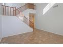 Bright foyer area with a staircase featuring wooden banisters and tile flooring at 42468 W Palmyra Ct, Maricopa, AZ 85138