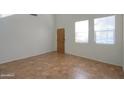 Bright room featuring tile floors, high ceilings and natural lighting from two large windows at 42468 W Palmyra Ct, Maricopa, AZ 85138