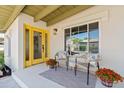 Inviting front porch with stylish seating, flower pots, and a cheerful yellow entrance door at 6001 N 10Th Way, Phoenix, AZ 85014