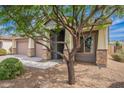 This home has a spacious front yard and an inviting entrance enhanced by stone accents and a mature tree at 809 W Coles Rd, Phoenix, AZ 85041