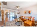 Bright living room featuring a leather sofa, ceiling fan and open floorplan to the kitchen and dining area at 8326 N 8Th St, Phoenix, AZ 85020