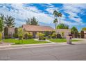 Charming single-story home with a well-manicured lawn, mature trees, and an attached two-car garage at 8851 S Juniper St, Tempe, AZ 85284