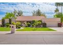 Charming single-story home with a well-manicured lawn, mature trees, and an attached two-car garage at 8851 S Juniper St, Tempe, AZ 85284