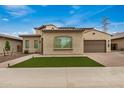 Inviting single-story home with tan stucco, tidy artificial turf, and a paved driveway leading to a two-car garage at 9508 W Jj Ranch Rd, Peoria, AZ 85383