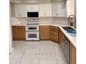 Modern kitchen with white and natural wood cabinets, stainless steel appliances, and white marble floors at 135 S Abalone Dr, Gilbert, AZ 85233