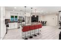 Modern kitchen with white cabinets, granite countertops, stainless steel appliances, and red bar seating at 1532 W Northern Ave, Phoenix, AZ 85021