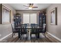 Formal dining room with dark wood furniture, a ceiling fan, and neutral paint, filled with decorative elements at 15422 W Ventura St, Surprise, AZ 85379
