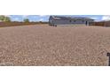 Large gravel backyard with a single-story home featuring solar panels at 18100 W College Dr, Goodyear, AZ 85395