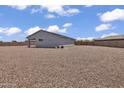 Large gravel backyard with a single-story home featuring solar panels at 18100 W College Dr, Goodyear, AZ 85395