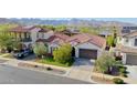 Stunning aerial view of a home with a tile roof and a manicured front lawn against a mountain backdrop at 20510 W White Rock Rd, Buckeye, AZ 85396