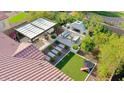 Overhead view of a luxurious outdoor living space with a built-in fireplace, pergola, and manicured landscaping at 20510 W White Rock Rd, Buckeye, AZ 85396