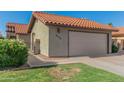Home exterior showcases a clay tile roof, two-car garage, and manicured lawn at 2154 E Forge Ave, Mesa, AZ 85204