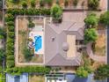 Aerial view of the property featuring a sparkling blue pool, mature landscaping, and a tennis court at 2285 E Plum St, Gilbert, AZ 85298