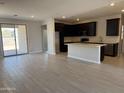 Inviting living room and kitchen with dark cabinets and ample space for entertaining at 22895 N 183Rd Dr, Surprise, AZ 85387