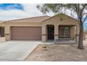 Cozy single-story home featuring a desert-landscaped yard, covered porch, and two-car garage at 23613 W Mobile Ln Ln, Buckeye, AZ 85326