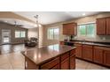 Spacious kitchen with a center island, stainless steel sink, and dark appliances at 23613 W Mobile Ln Ln, Buckeye, AZ 85326