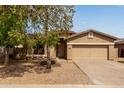 Charming single-story home with a two car garage, desert landscaping, and mature shade trees at 2590 S Buckaroo Trl, Gilbert, AZ 85295