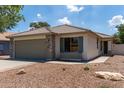 Attractive single-story home featuring a tile roof, well maintained landscaping, and a two-car garage at 4143 E Sundance Ave, Gilbert, AZ 85297