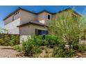 This well-maintained yard features desert landscaping with lush green shrubs and trees at 6305 W Pleasant Oak Ct, Florence, AZ 85132