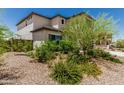 This well-maintained yard features desert landscaping with lush green shrubs and trees at 6305 W Pleasant Oak Ct, Florence, AZ 85132
