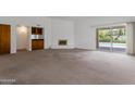 Spacious living room with a fireplace, wet bar, and sliding glass doors to the pool at 7530 E North Ln, Scottsdale, AZ 85258