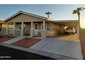 A charming home with a covered front porch, desert landscaping and a carport at 9302 E Broadway Rd # 157, Mesa, AZ 85208