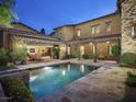 Backyard pool with stone patio surrounded by manicured landscaping offers a serene retreat at 10287 E Diamond Rim Dr, Scottsdale, AZ 85255