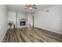 Bright living room featuring luxury vinyl plank flooring and decorative fireplace, with view to dining area at 1050 S Stapley Dr # 62, Mesa, AZ 85204